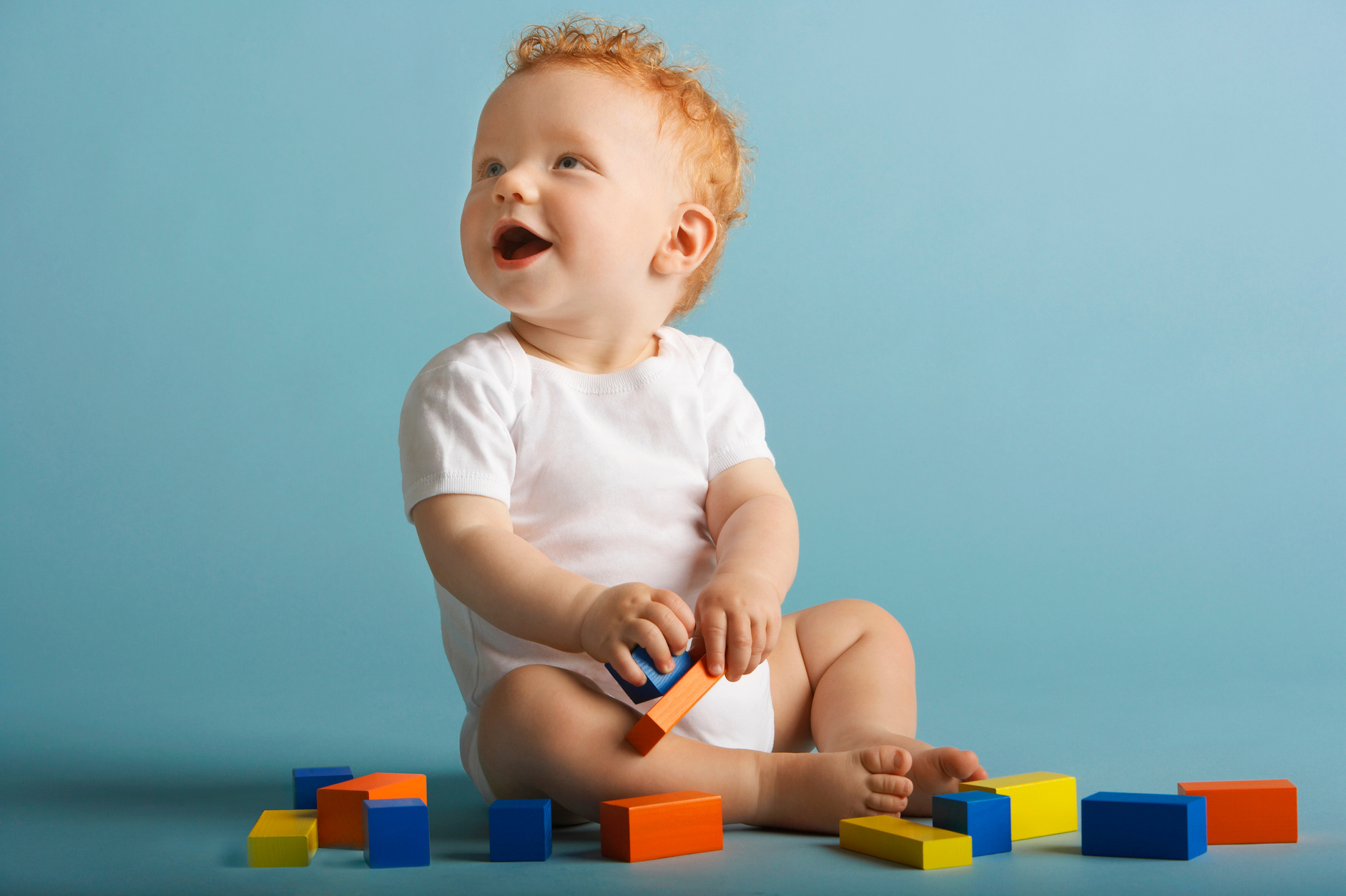 Redheaded baby playing with blocks