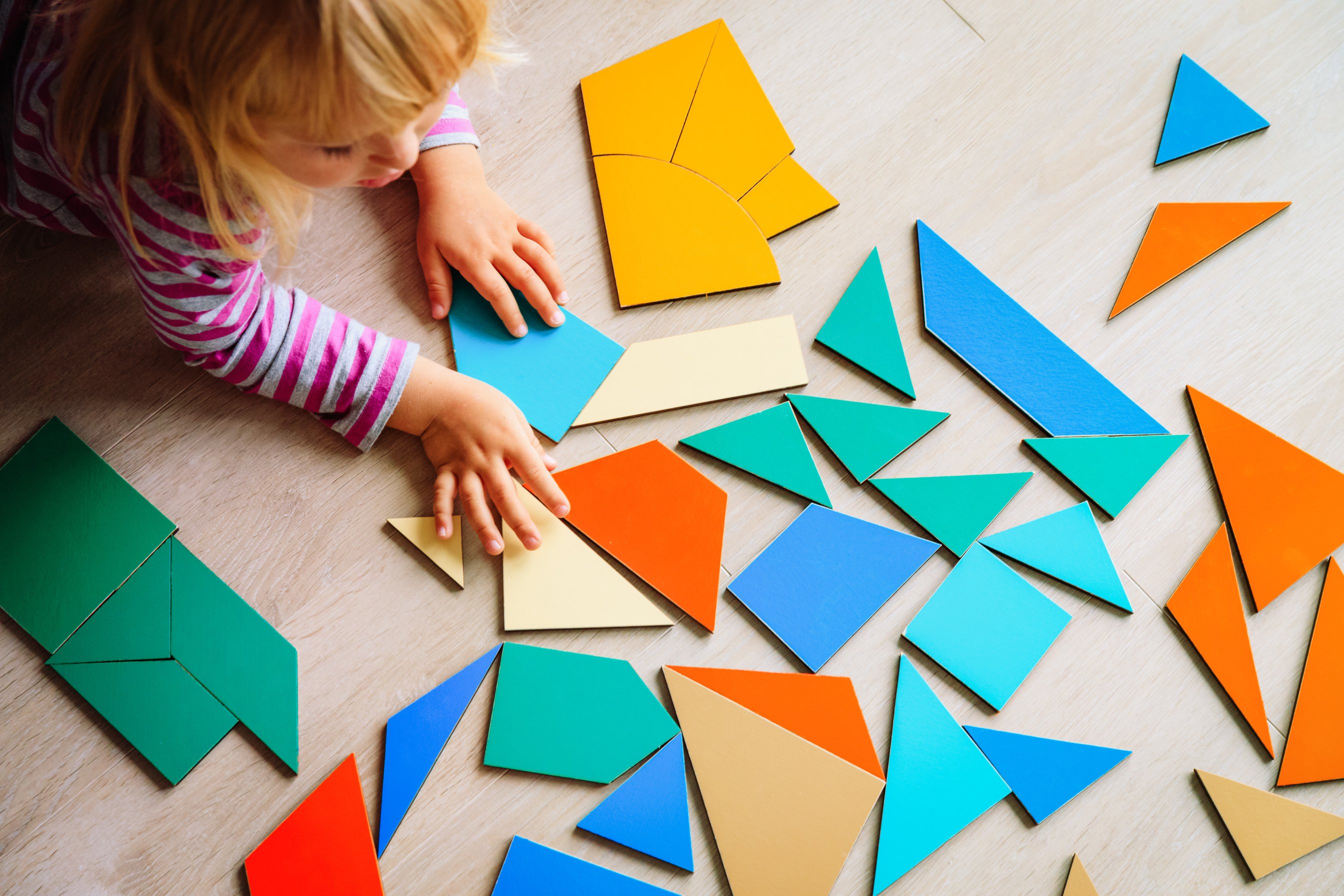 little girl playing with puzzle in school or daycare